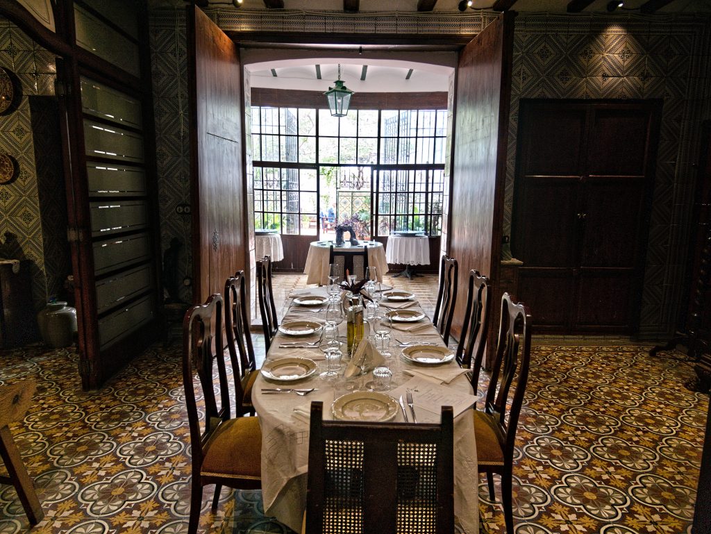 Dining area with lace-dressed table by tall windows, Casa Mayolica